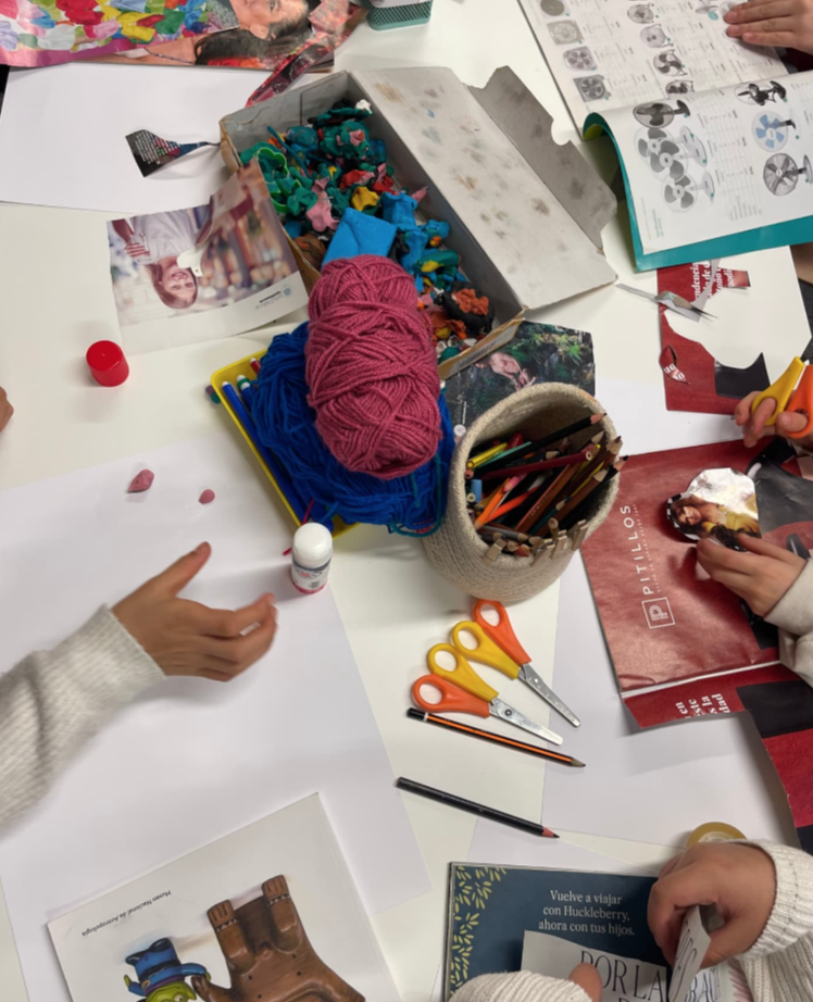 Manos creando un collage con revistas, papeles, lanas y tijeras