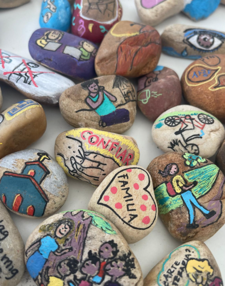 Piedras pintadas a mano con escenas y palabras como confiar y familia
